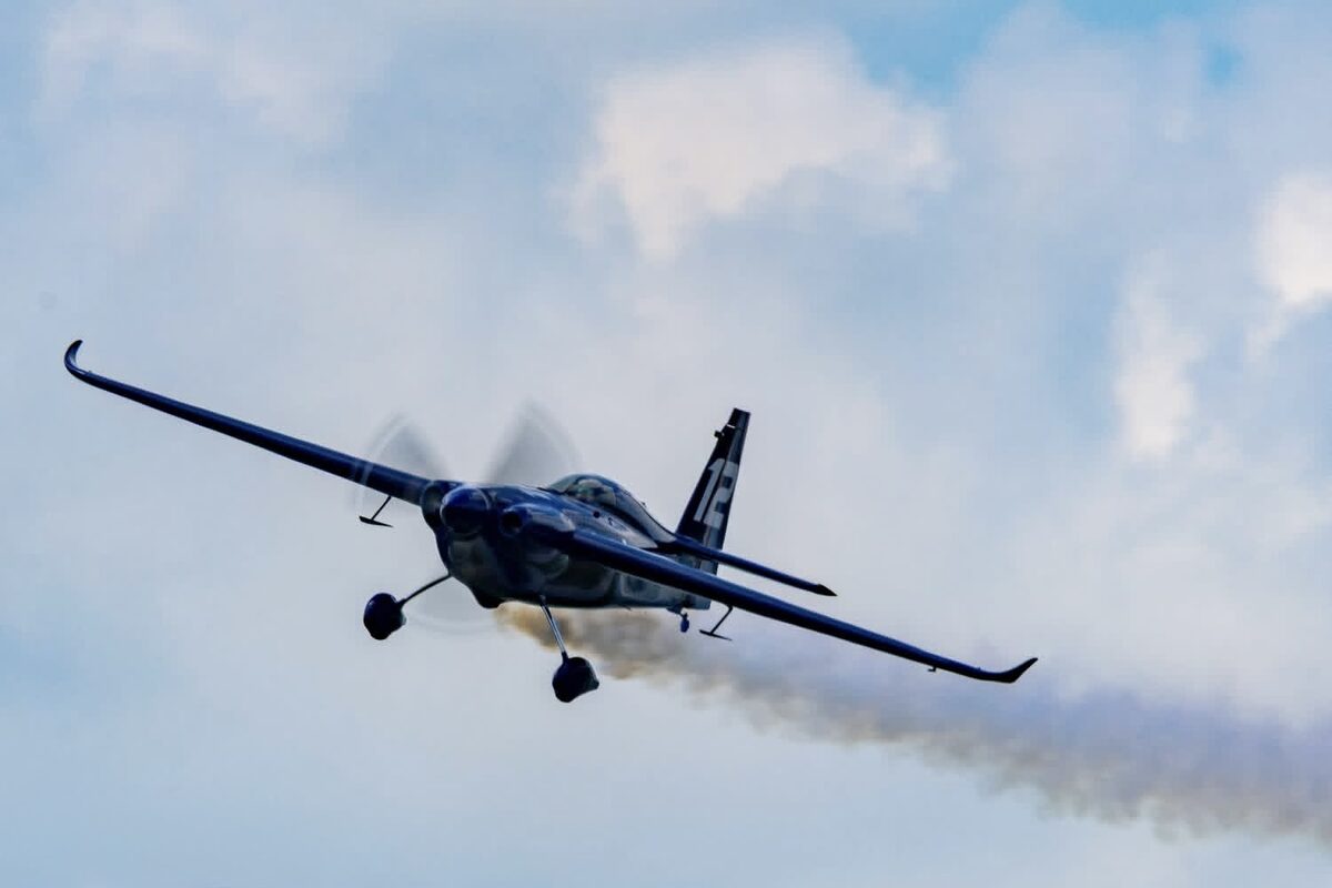 The Edge 540 v3 head-on in a knife-edge pass, smoke streaming behind it